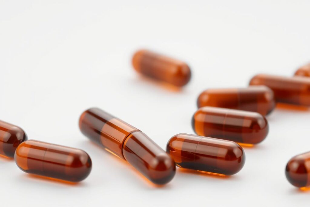 High-quality close-up image of a group of Schwarzkümmelöl (black cumin oil) supplement capsules set against a plain white background. The capsules should be in focus, with a soft, even lighting that highlights their smooth, glossy surfaces and captures the rich, amber color of the oil inside. The image should convey a sense of purity, naturalness, and health, reflecting the premium quality and benefits of the product. The composition should be simple and uncluttered, allowing the capsules to be the central focus. High-quality close-up image of a group of Schwarzkümmelöl (black cumin oil) supplement capsules set against a plain white background. The capsules should be in focus, with a soft, even lighting that highlights their smooth, glossy surfaces and captures the rich, amber color of the oil inside. The image should convey a sense of purity, naturalness, and health, reflecting the premium quality and benefits of the product. The composition should be simple and uncluttered, allowing the capsules to be the central focus.